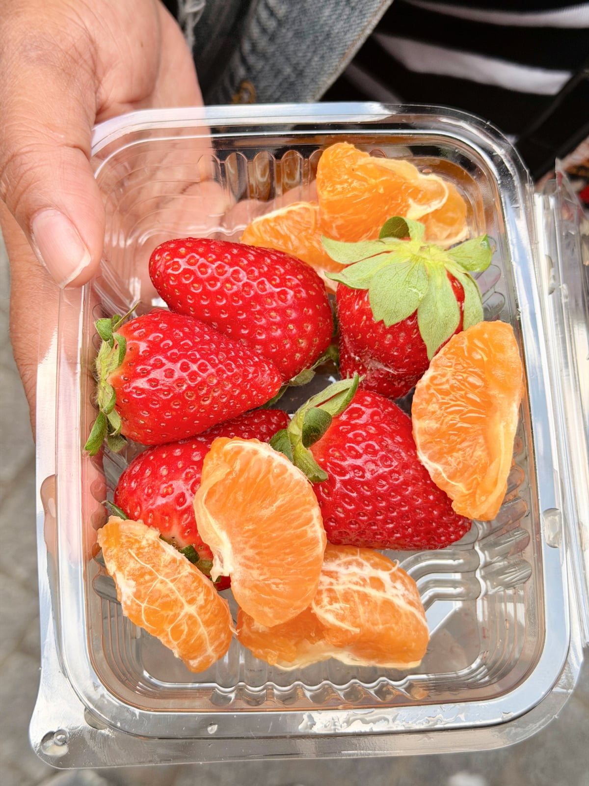 Fresh strawberries and peeled mandarin orange slices sold at a Madrid fruit market.