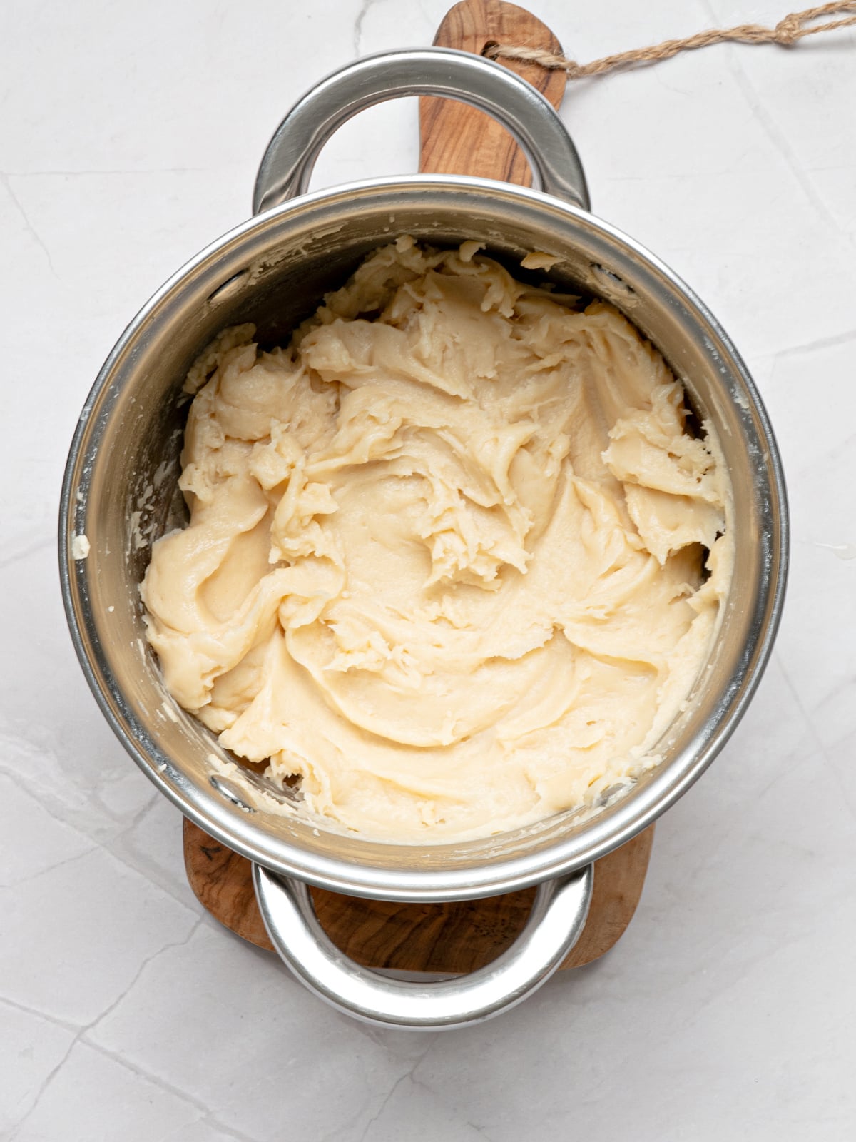 Freshly mixed churro dough in a saucepan after the egg and vanilla have been fully incorporated into the batter.