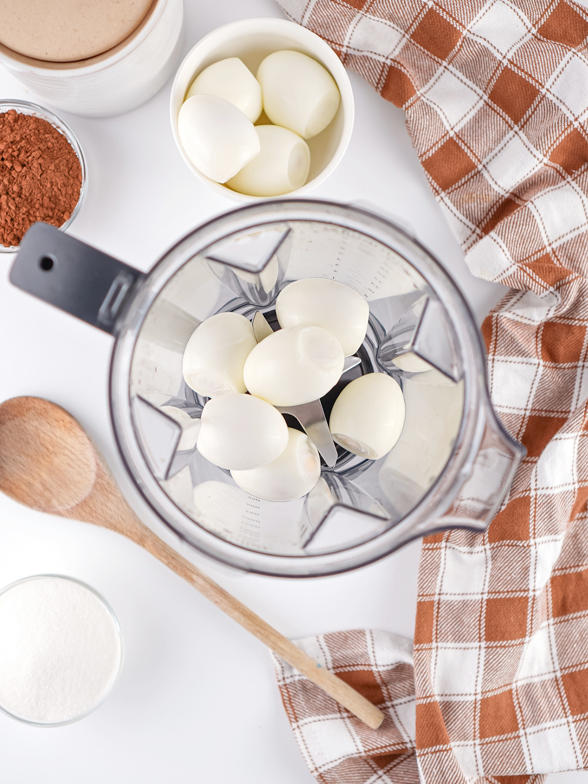 Peeled hard-boiled eggs in a blender ready to be blended into a high-protein chocolate pudding dessert.
