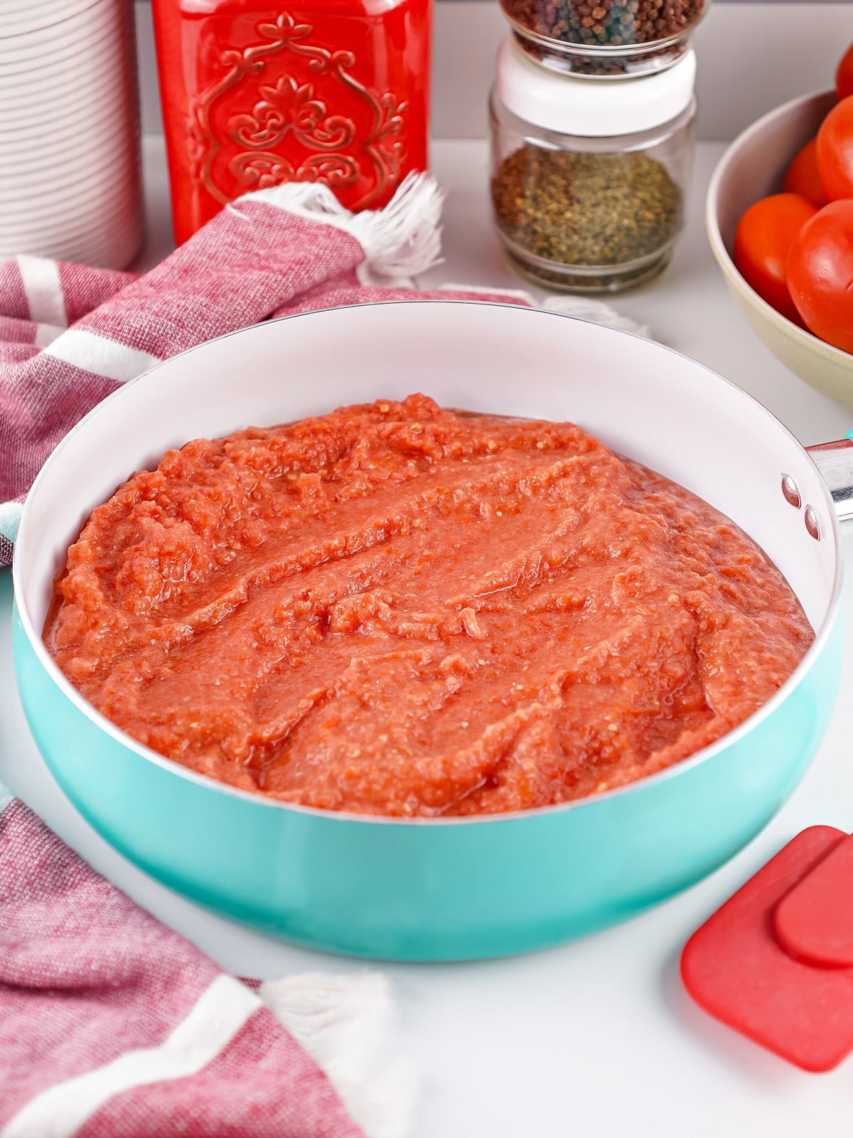 Tomato puree cooking in a skillet as it reduces into thick homemade tomato paste.