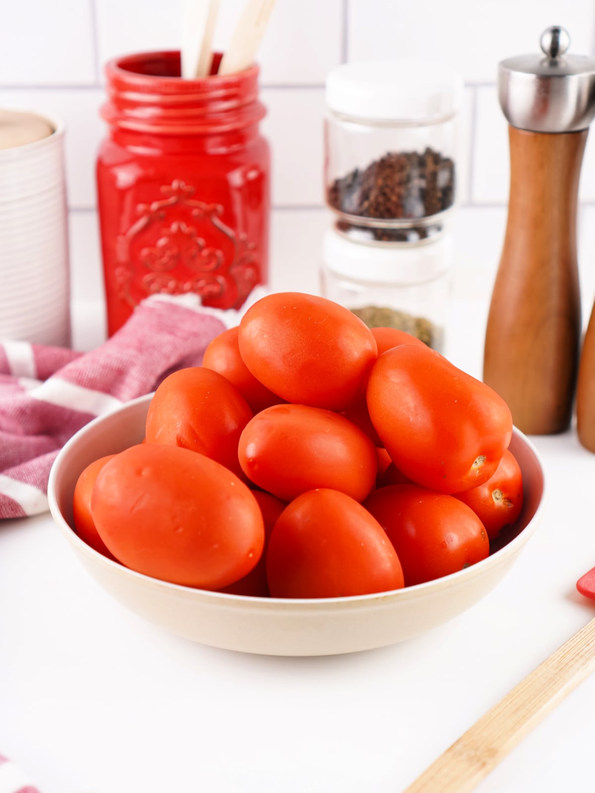 Bowl filled with fresh Roma tomatoes ready to make homemade tomato paste.