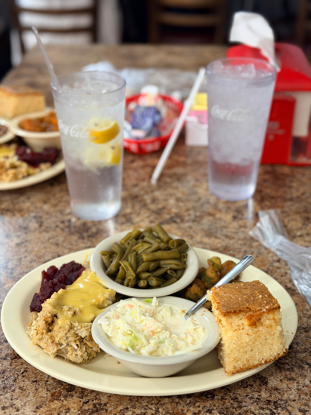 Southern meat and three lunch with chicken, green beans, fried okra, coleslaw, cranberry sauce, and cornbread.