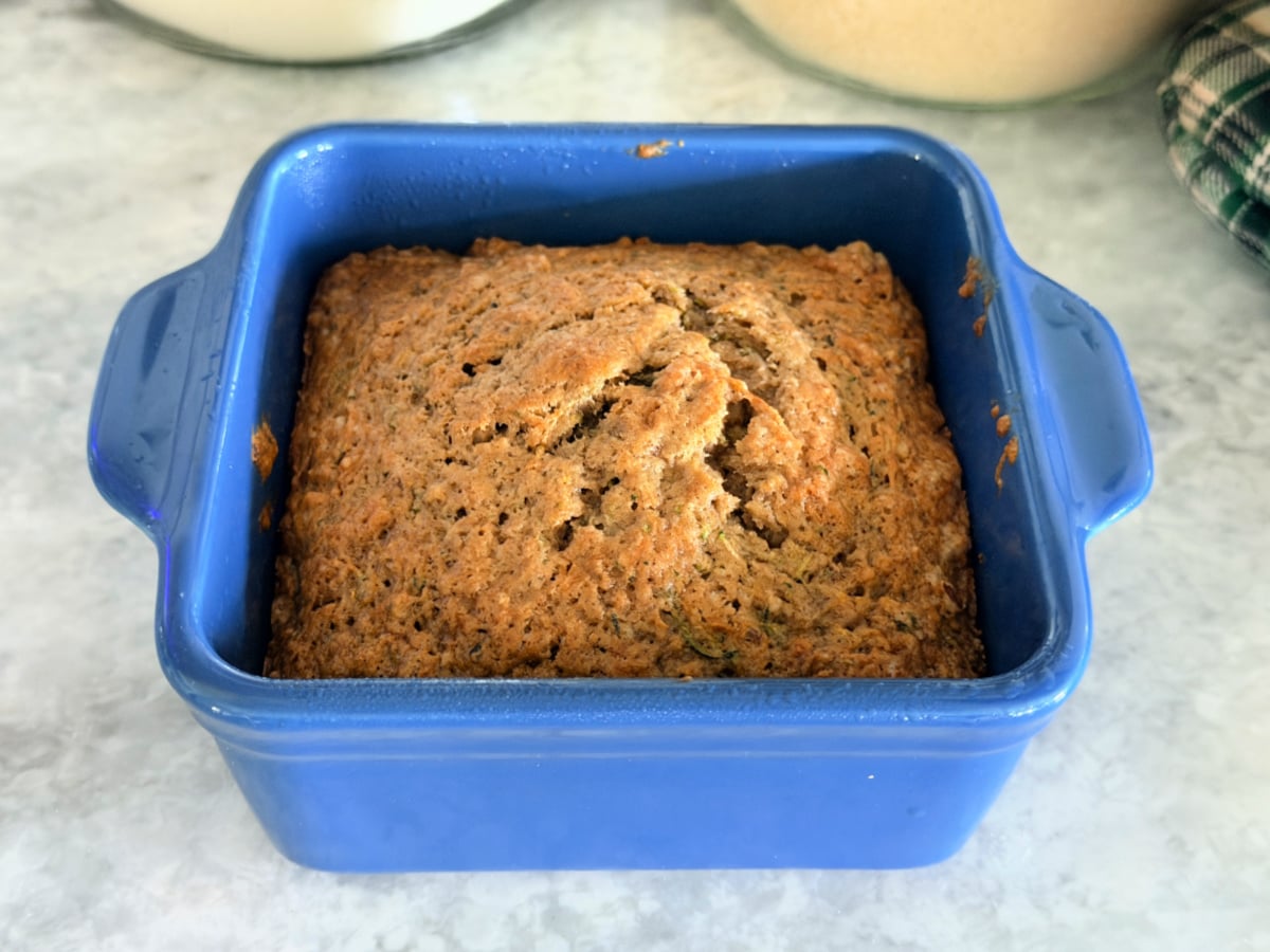 Small-batch zucchini bread baked until golden brown in a blue ceramic dish.