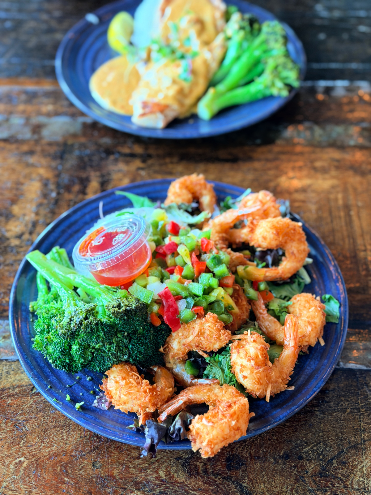 Coconut shrimp with mixed greens, diced pineapple pico, steamed broccoli, and sweet chili sauce.