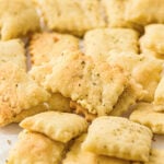 Close-up of golden sourdough discard crackers sprinkled with dried herbs.